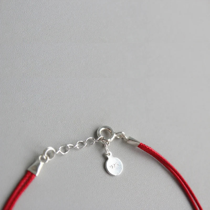 Armband Fini - Seitenansicht zeigt die Kombination aus Silber und rotem Faden" "Armband Fini aus 925 Silber - Draufsicht mit geometrischem Muster